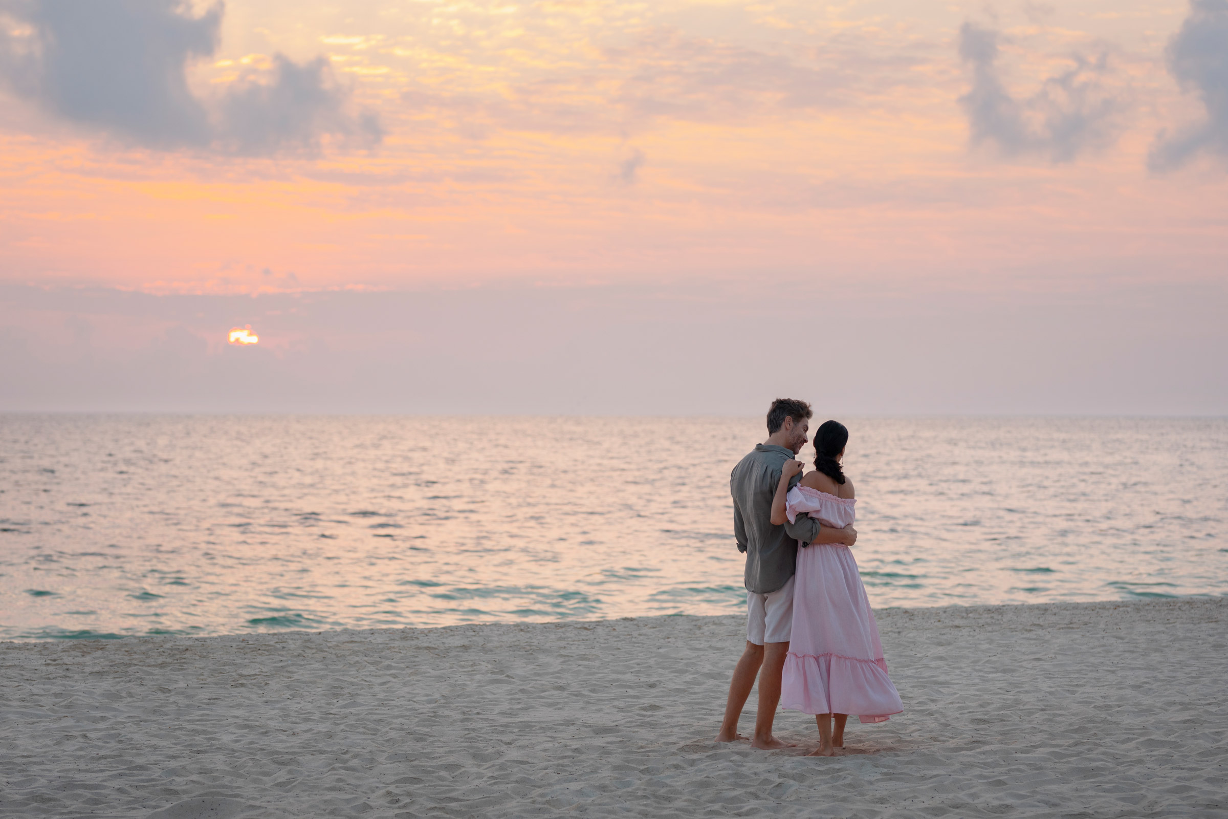 Couple looking at the sunset by the ocean in Excellence Coral Playa Mujeres