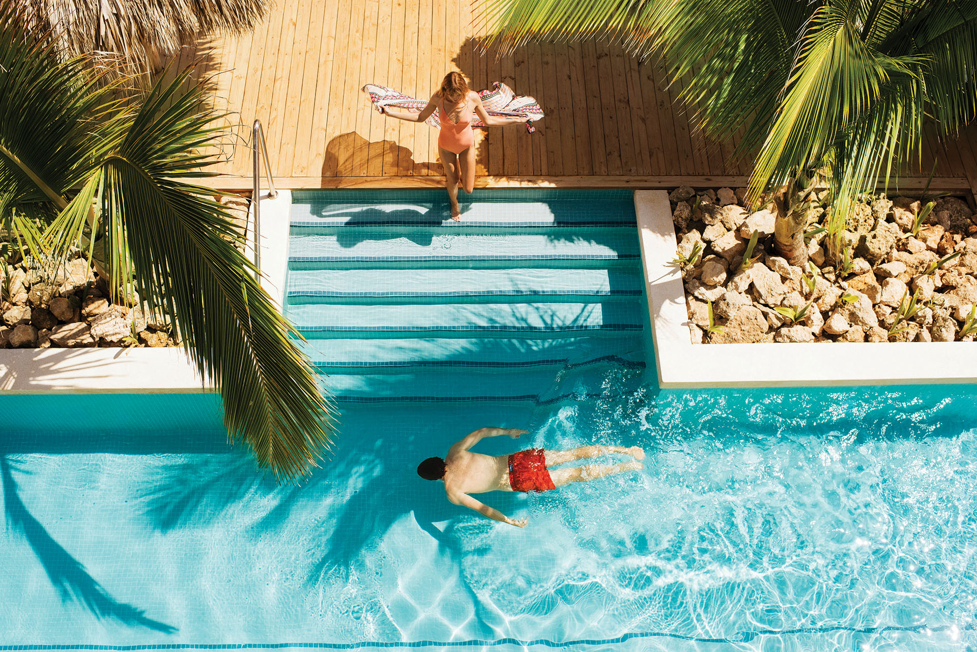 A couple wearing beachwear by the pool in Excellence El Carmen