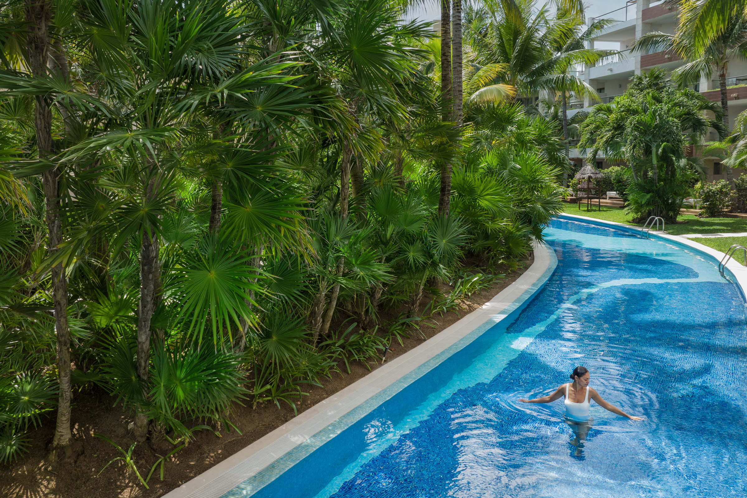 Woman swimming in Excellence Playa Mujeres winding rivier Woman swimming in Excellence Playa Mujeres winding rivier