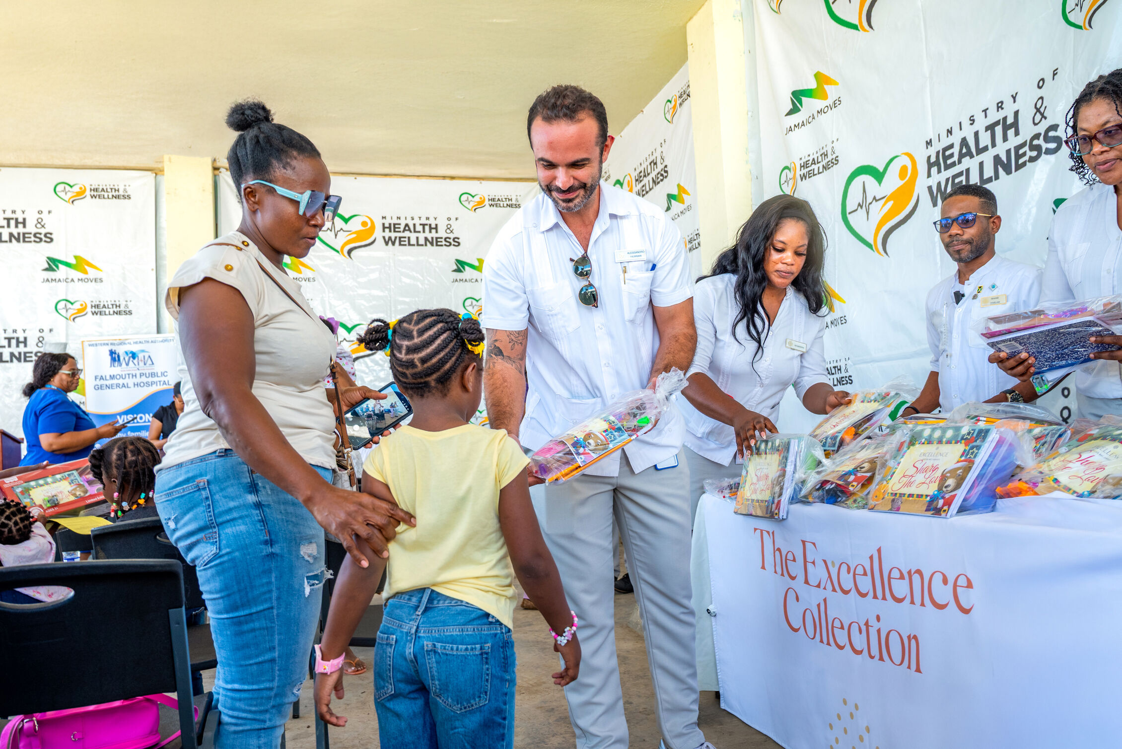 Jamaican woman and child receiving donations from The Excellence Collection