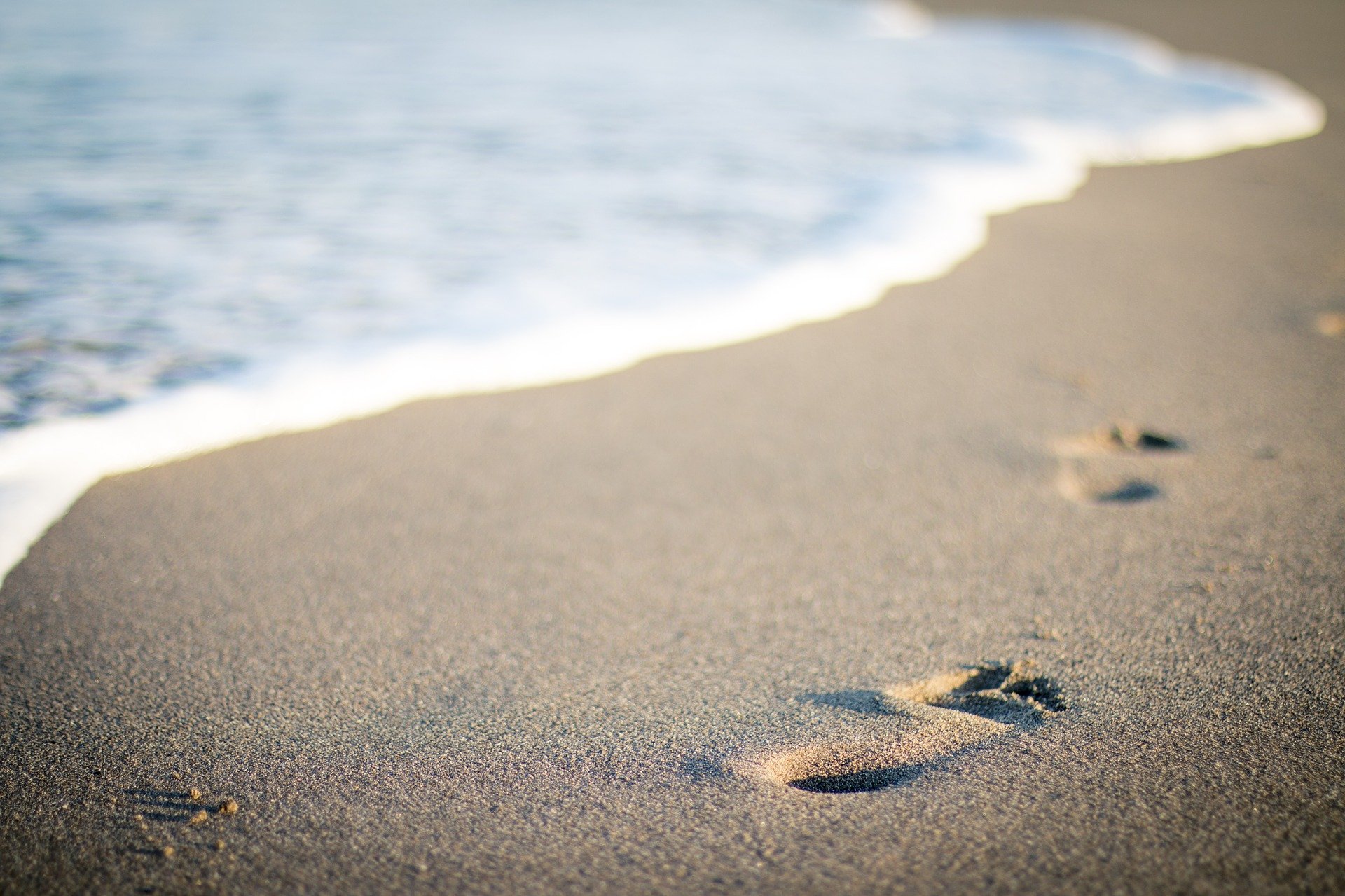 Footsteps in the sand on a beach where a wayfarer has been