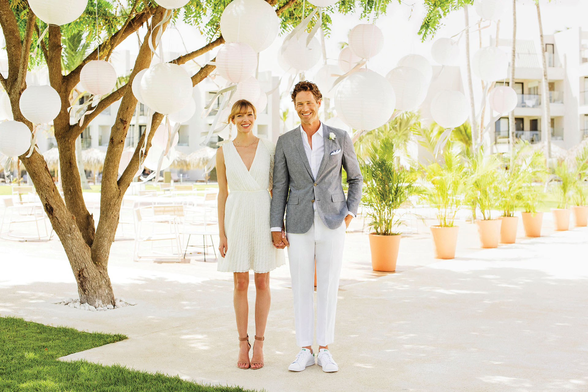 Newlywed couple standing in front of a Caribbean resort