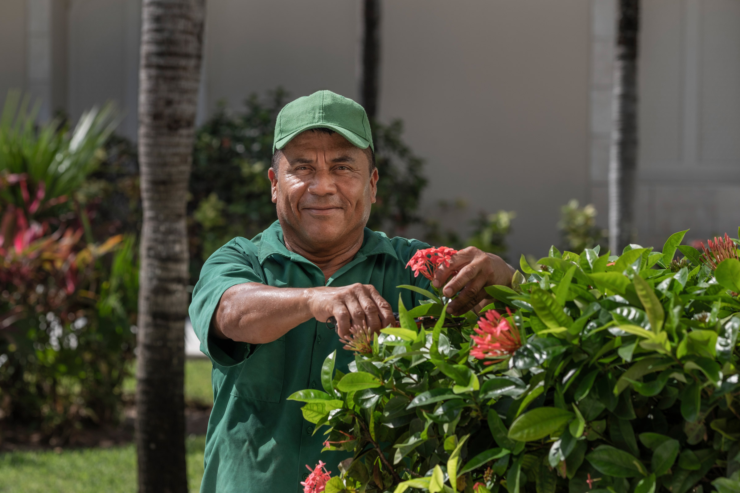 Smiling man working in the gardens of a resort